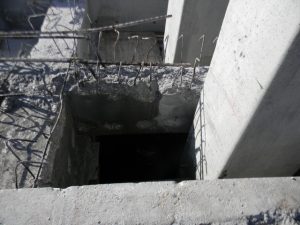 Dock spall with rebar shown off before being repaired