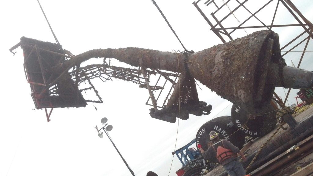 floating crane collecting salvage from the water and placing on barge