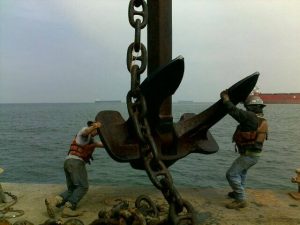 Precon Marine workers moving giant anchor