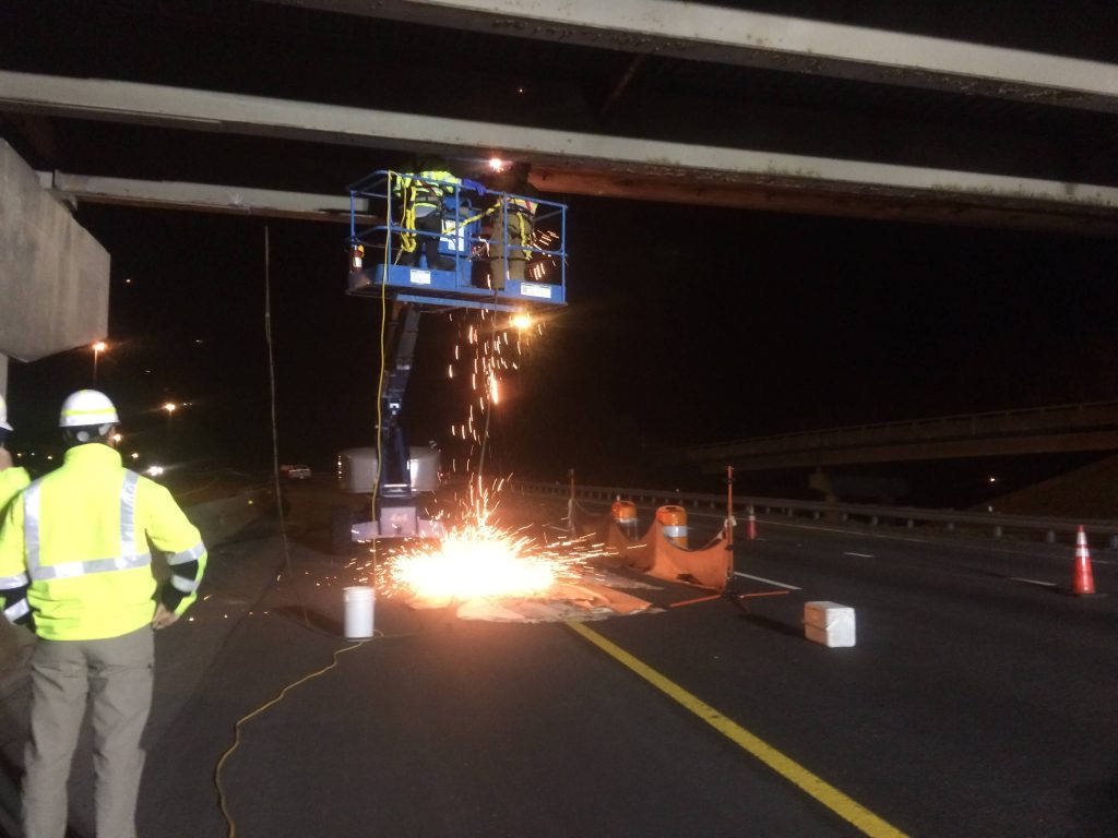 IMG_0340 precon marine construction workers repairing a steam beam under a bridge while other works oversee their progress