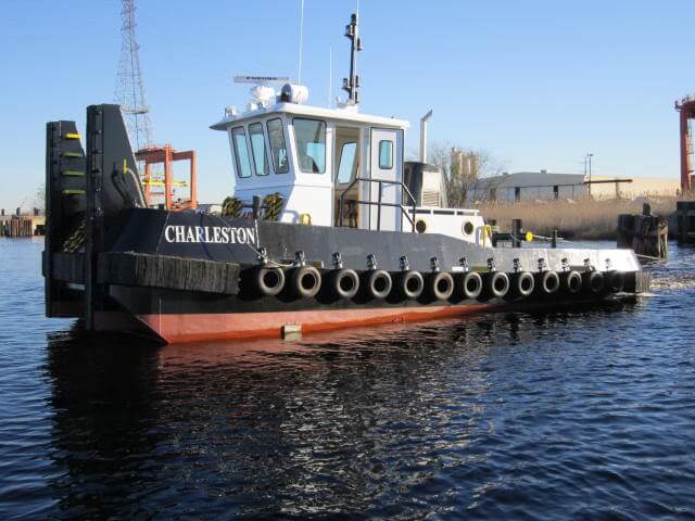 freshly manufactured tugboat in the water with a new coat of paint