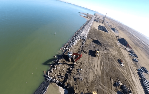 dutch angle image of a crane placing riprap stones for shoreline restoration