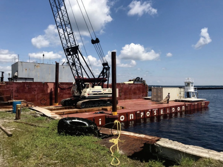 Poseidon-20 precon marine's poseidon sectional barge holding a construction crane floating near a dock