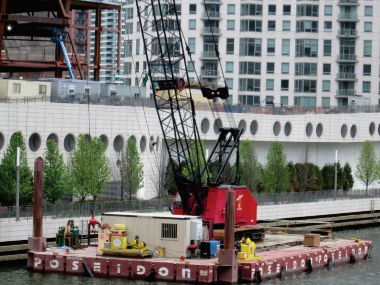 Poseidon-40 poseidon sectional barge in use with a crane moving construction materials on a river