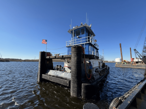 Screen Shot 2025-02-18 at 11.38.36 AM Precon Marine tugboat named Dotti J floating in the Chesapeake bay with crew members on its deck