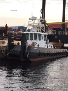 Tampa-tug (1) Tugboat named Tampa docked on a pier by a shiipyard